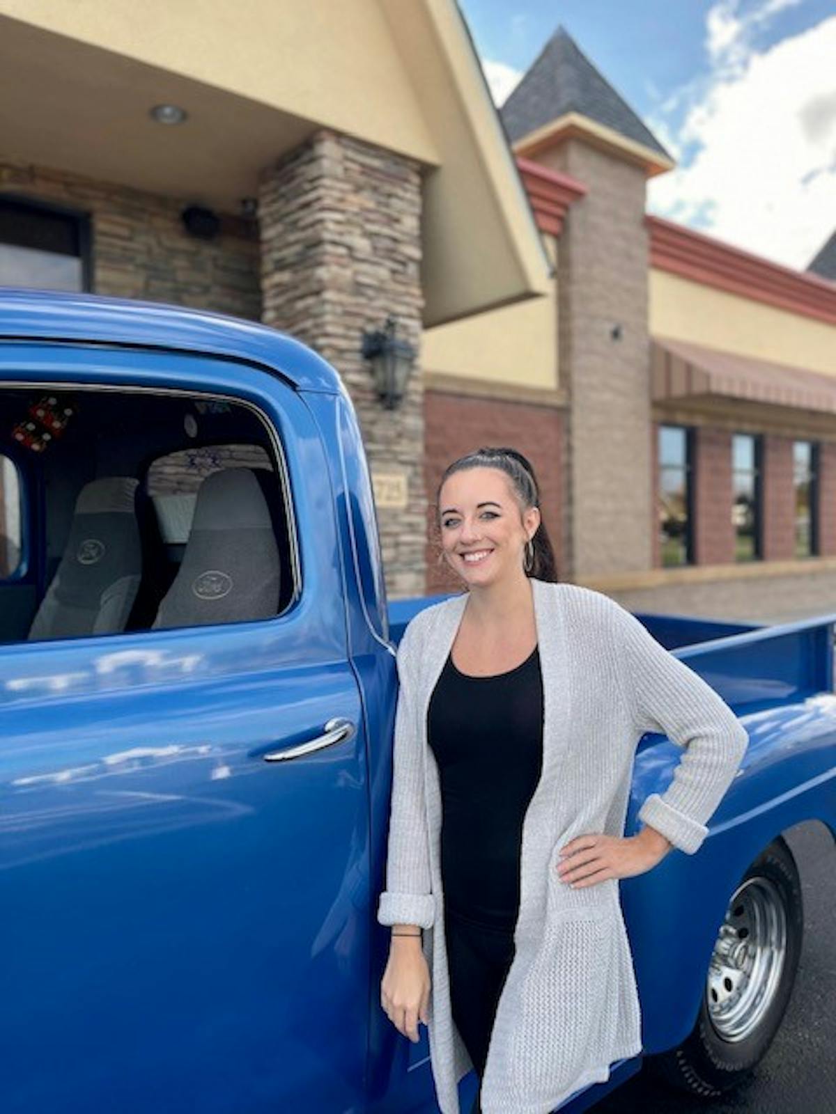 a person standing in front of a blue car