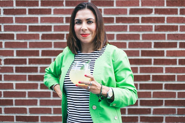 a woman standing in front of a brick wall