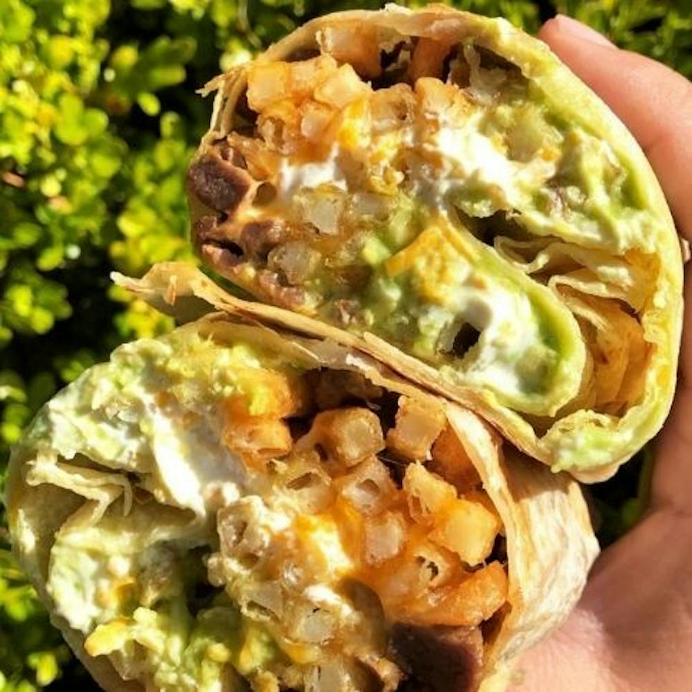 Rose Park’ top Cali burrito spot prepared burrito for customer.