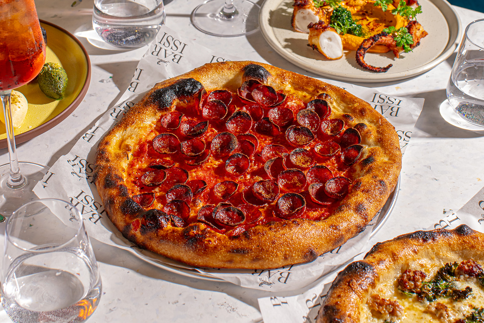 a pizza sitting on top of a table full of food