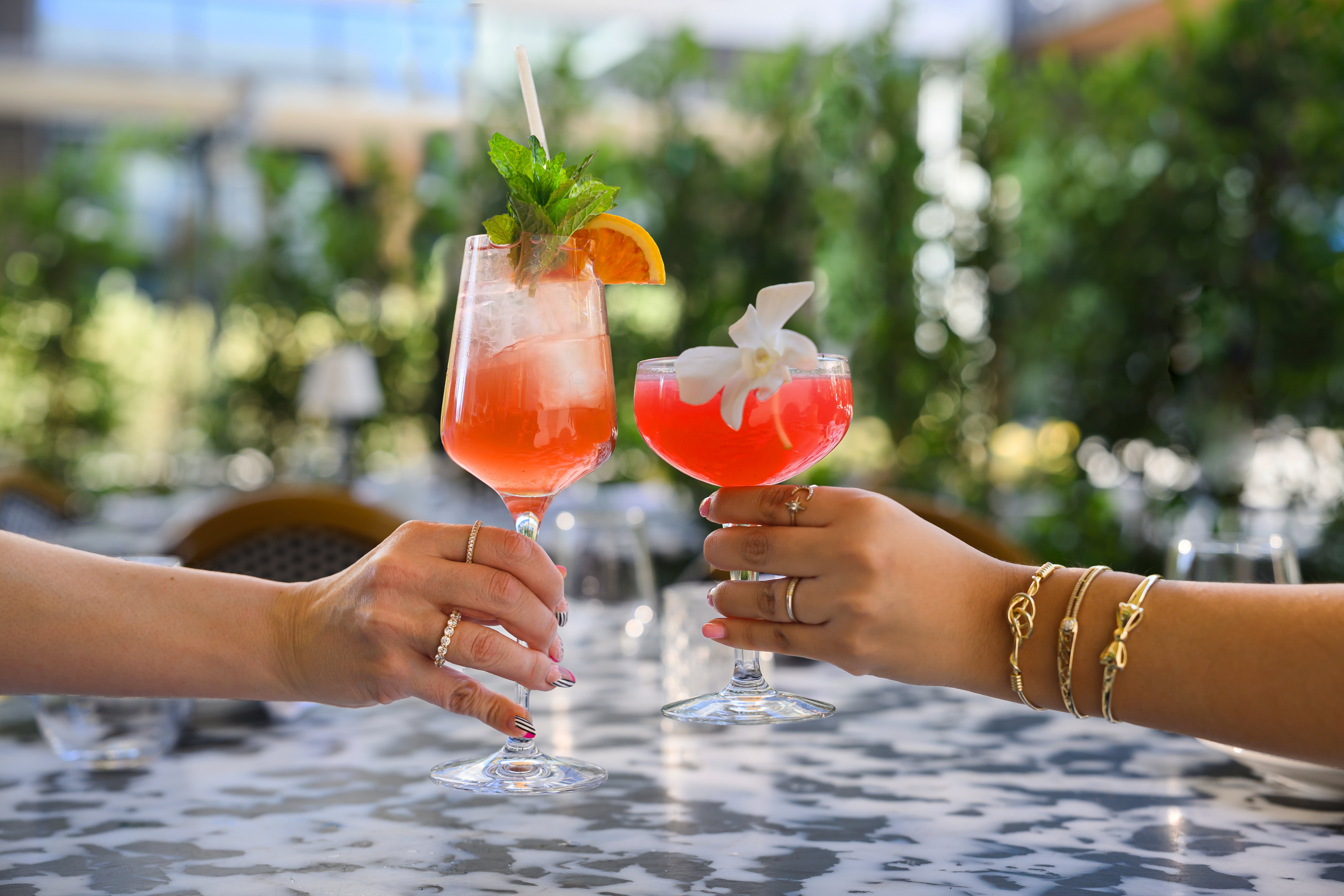 two hands holding drinks