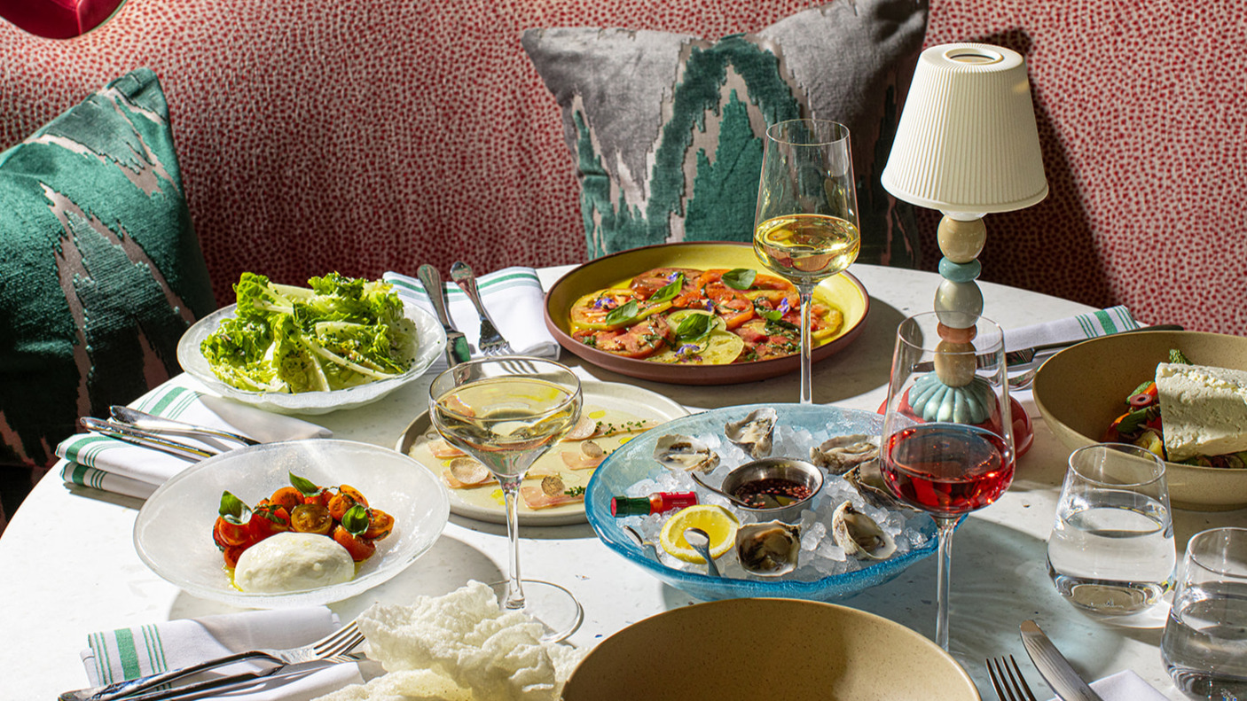 a table with plates of food and wine glasses