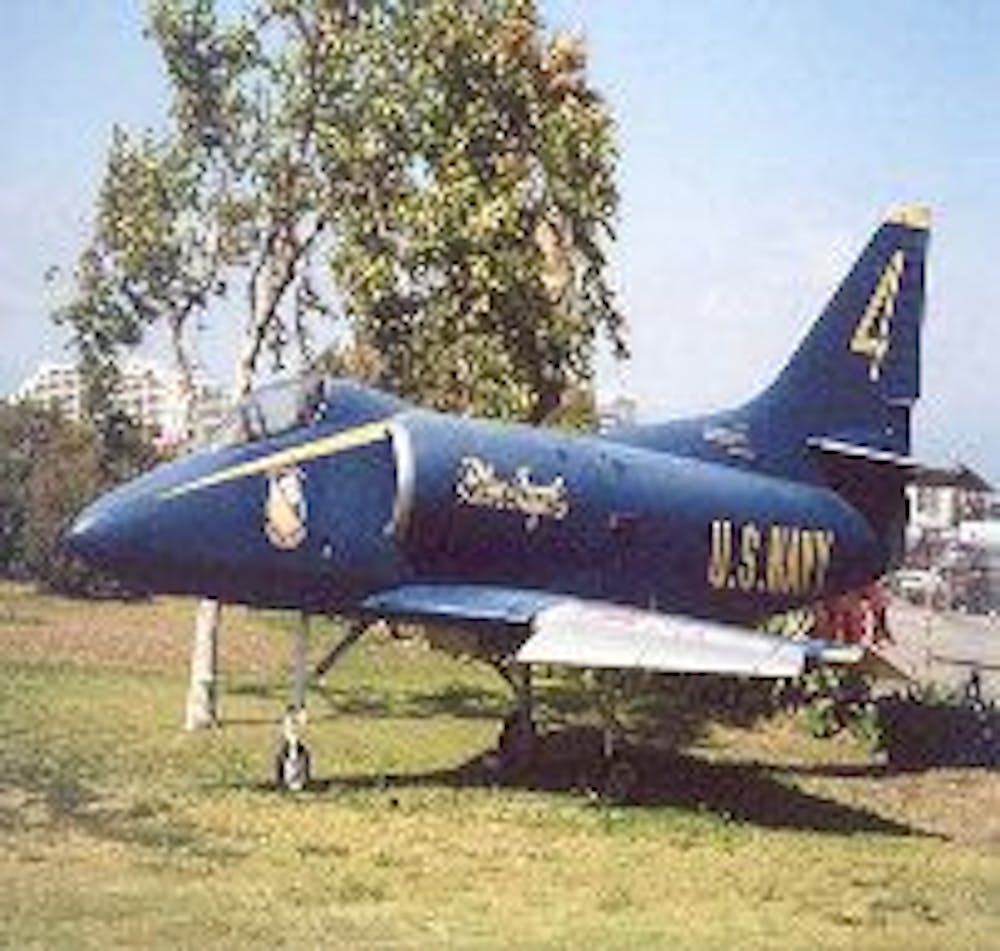 a fighter jet sitting on top of a grass covered field
