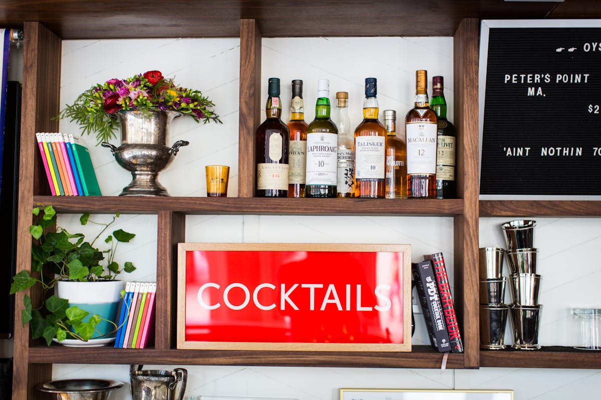 a stand full of books , flowers and wine bottles