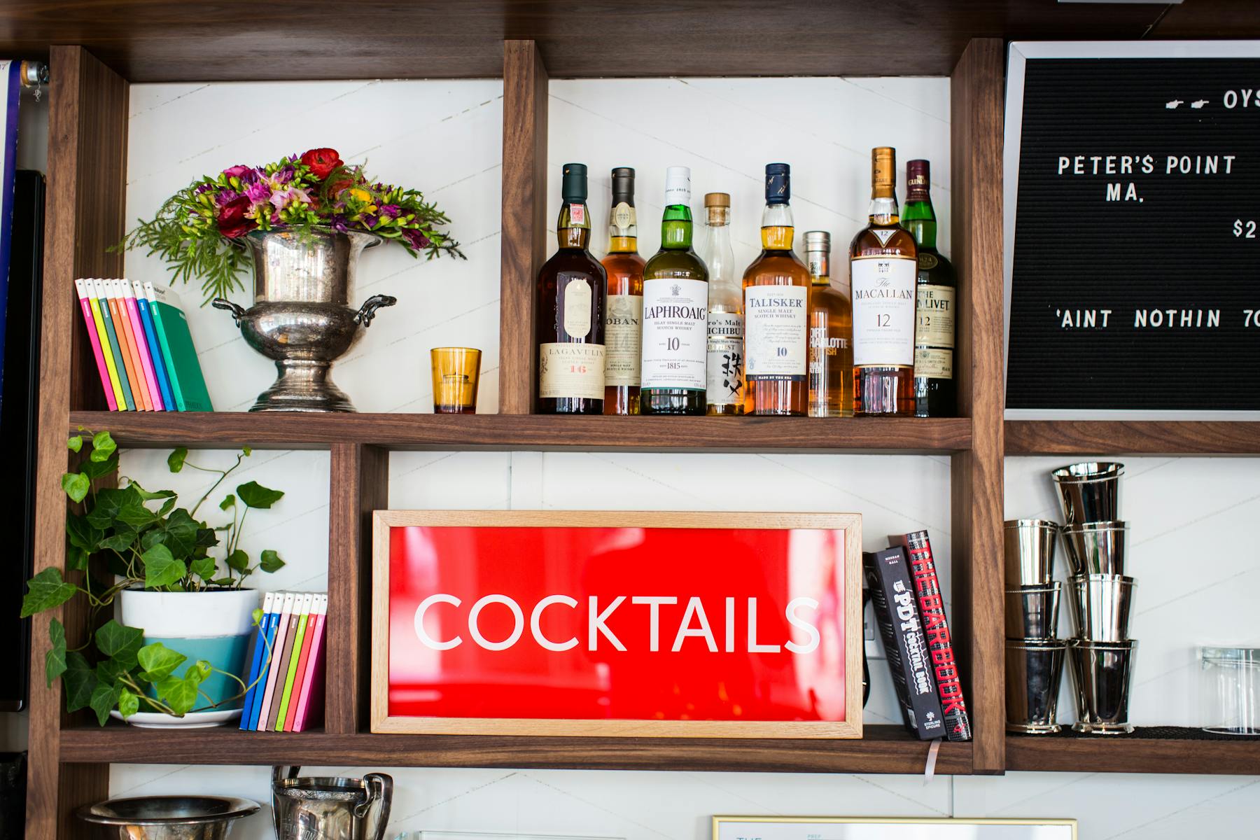 a stand full of books, flowers and wine bottles