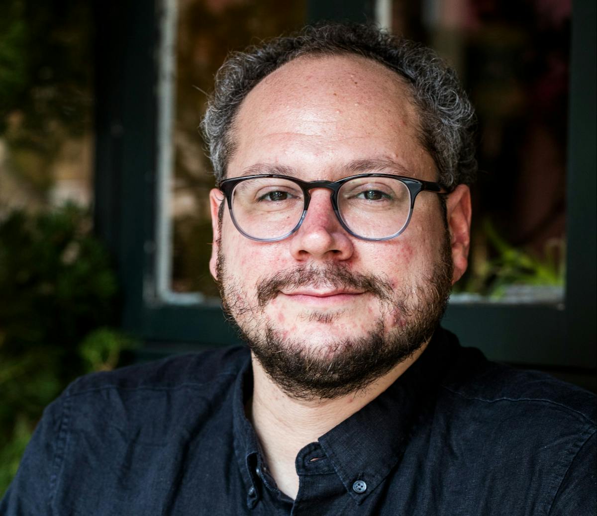 a man wearing glasses and looking at the camera