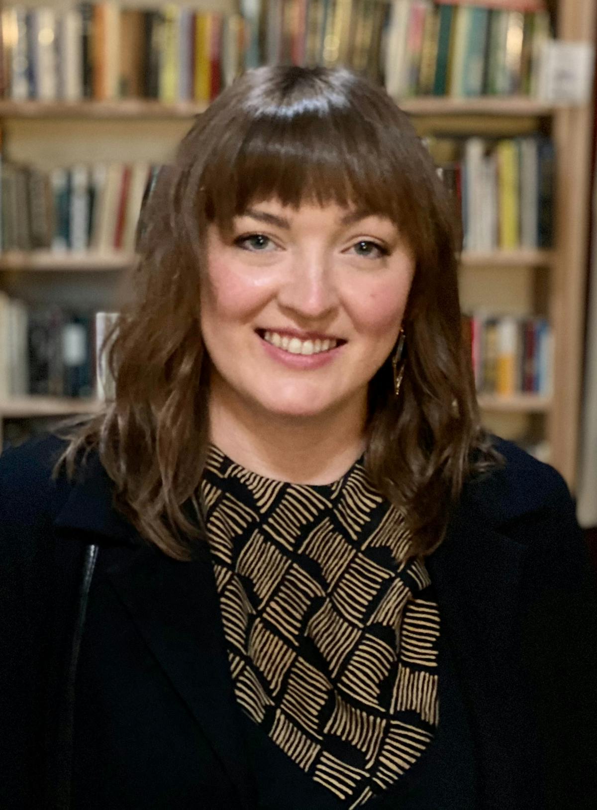 a person standing in front of a book shelf