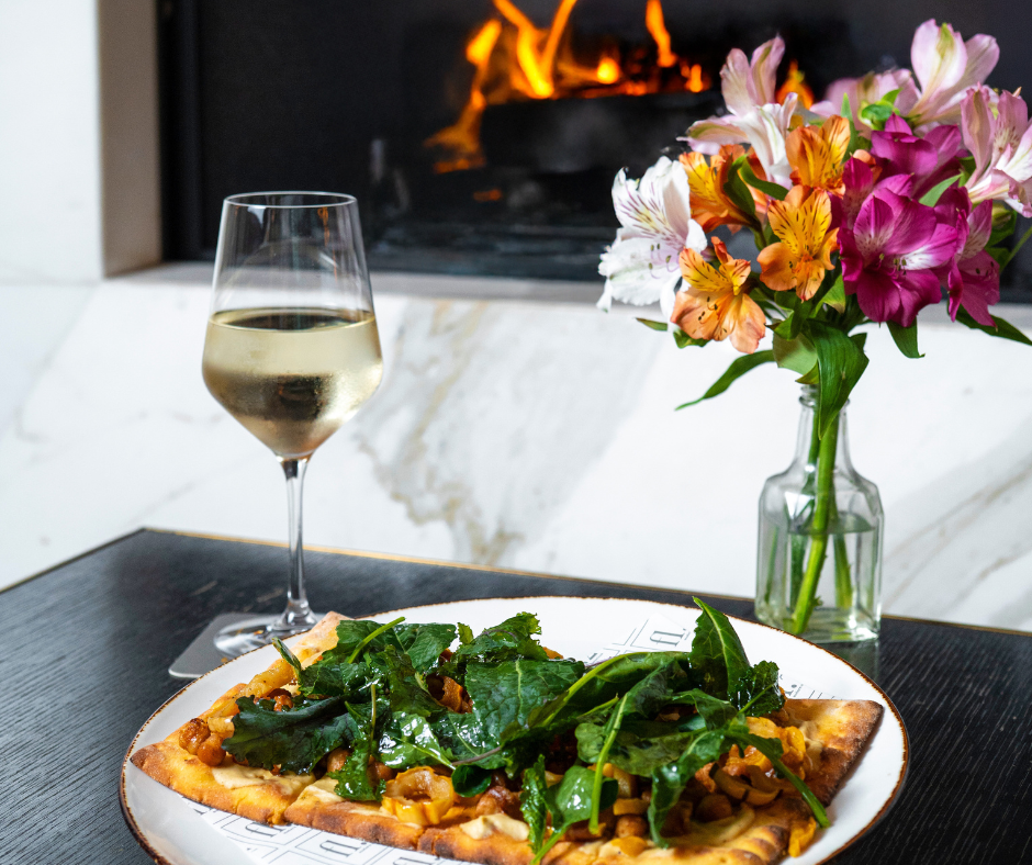 a close up of a plate of food with a glass of wine