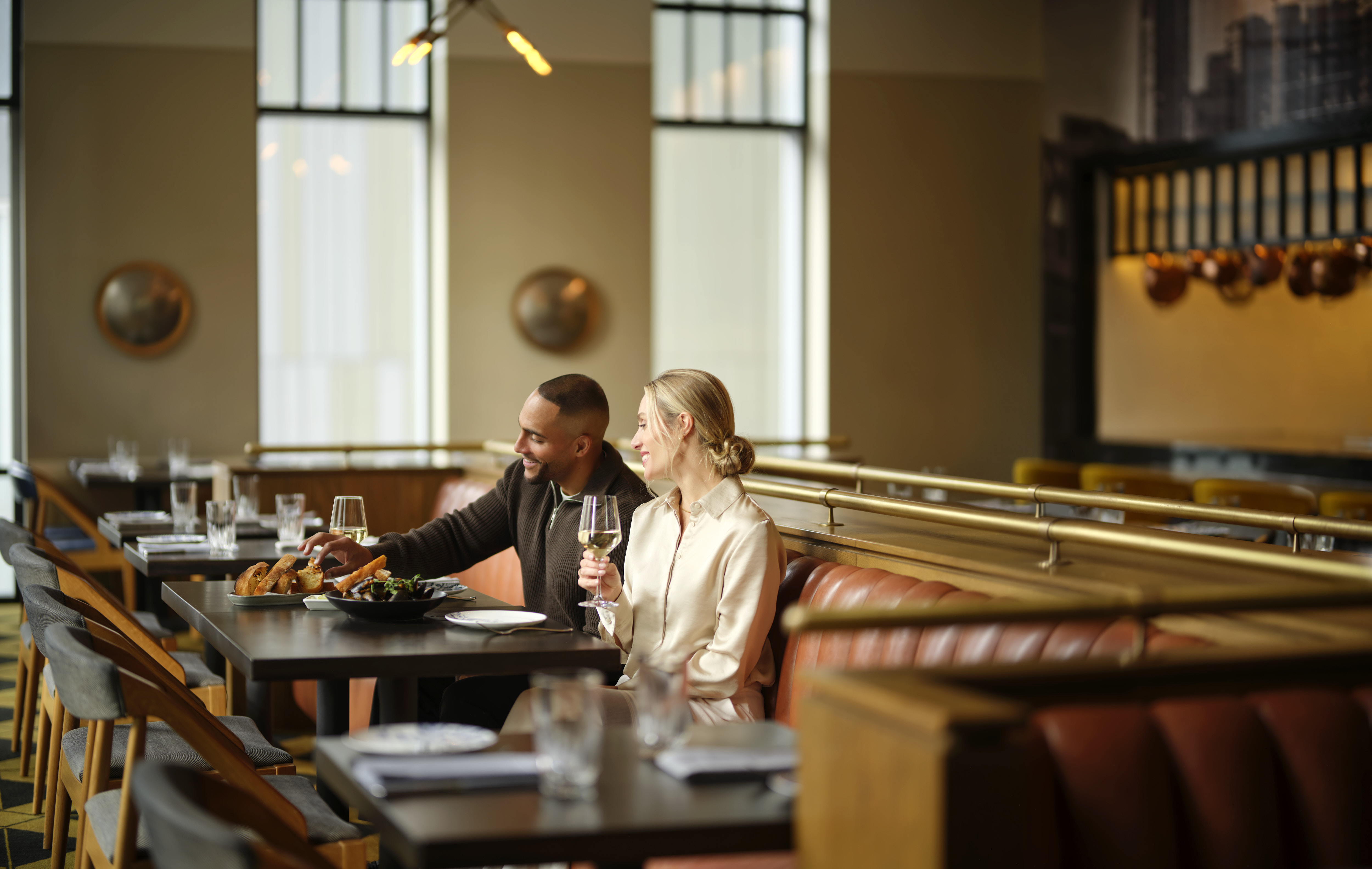 a man and woman sitting at a table with food