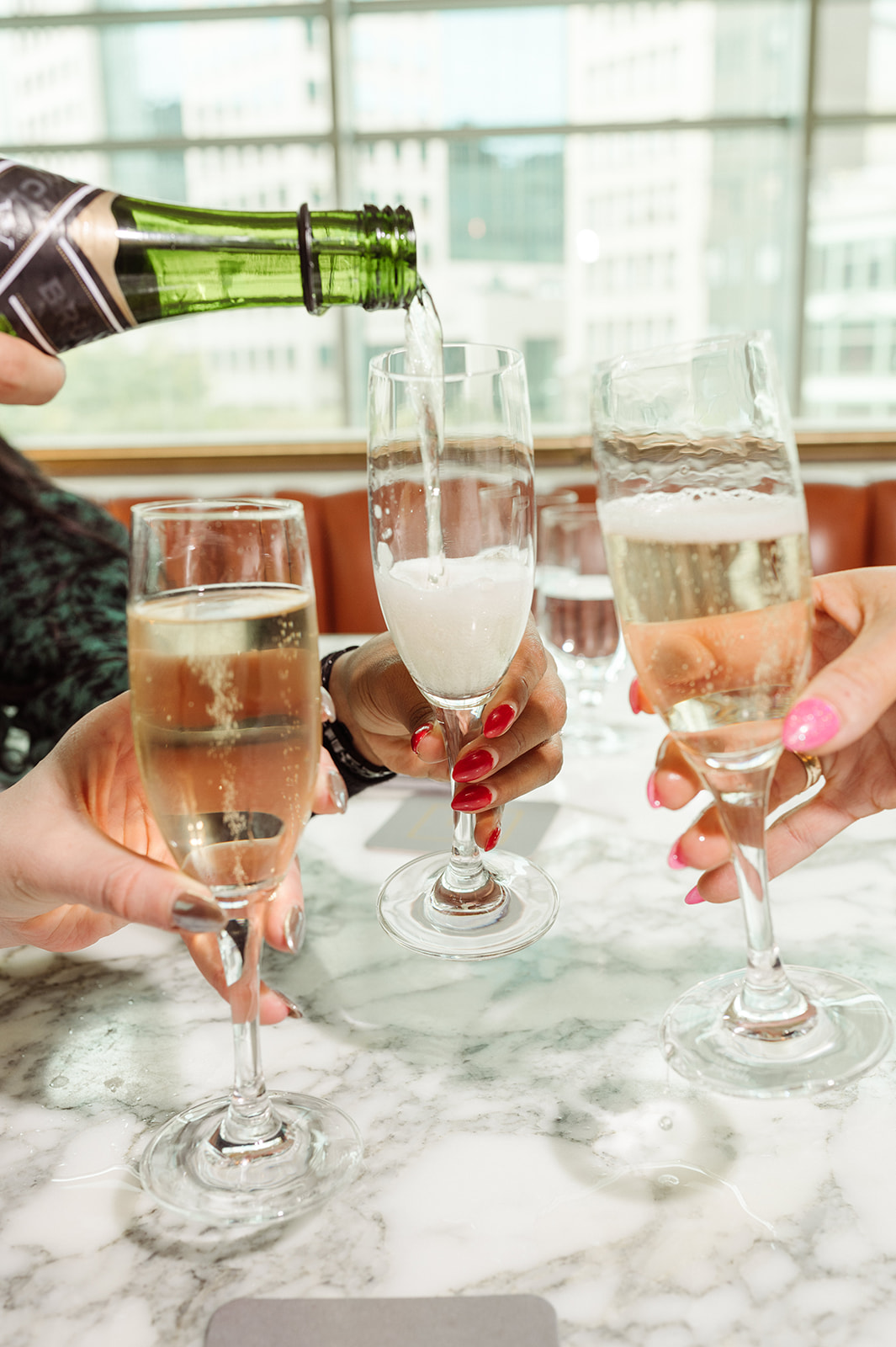 a person sitting at a table with wine glasses