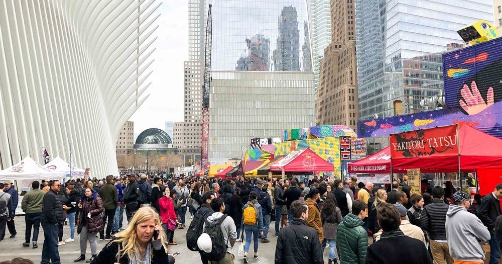 a group of people walking down the street in front of a crowd