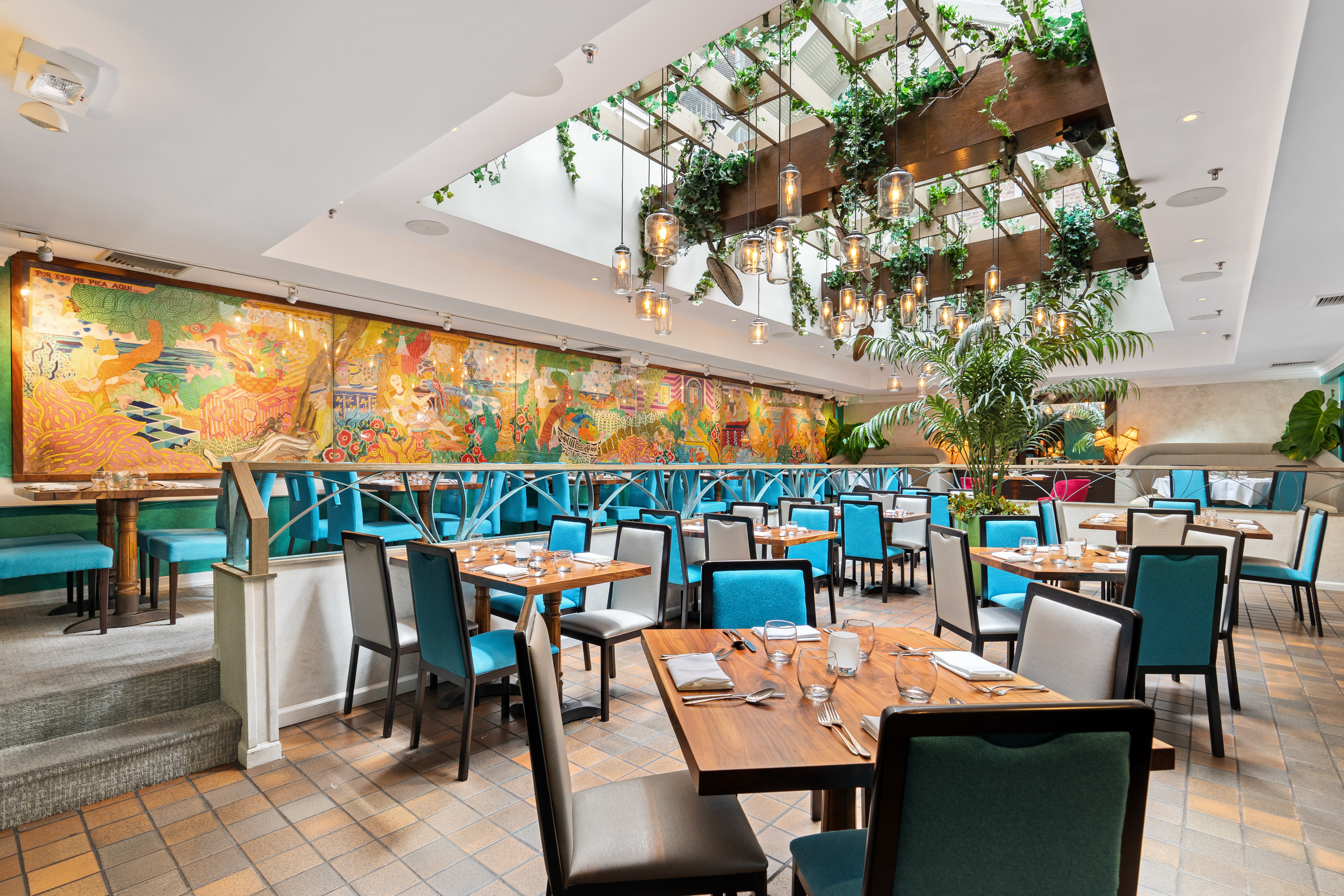 Skylit dining room with greenery and turquoise seating