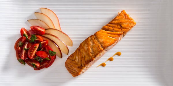 Plated Salmon with tomato basil salad and gourmet style apples
