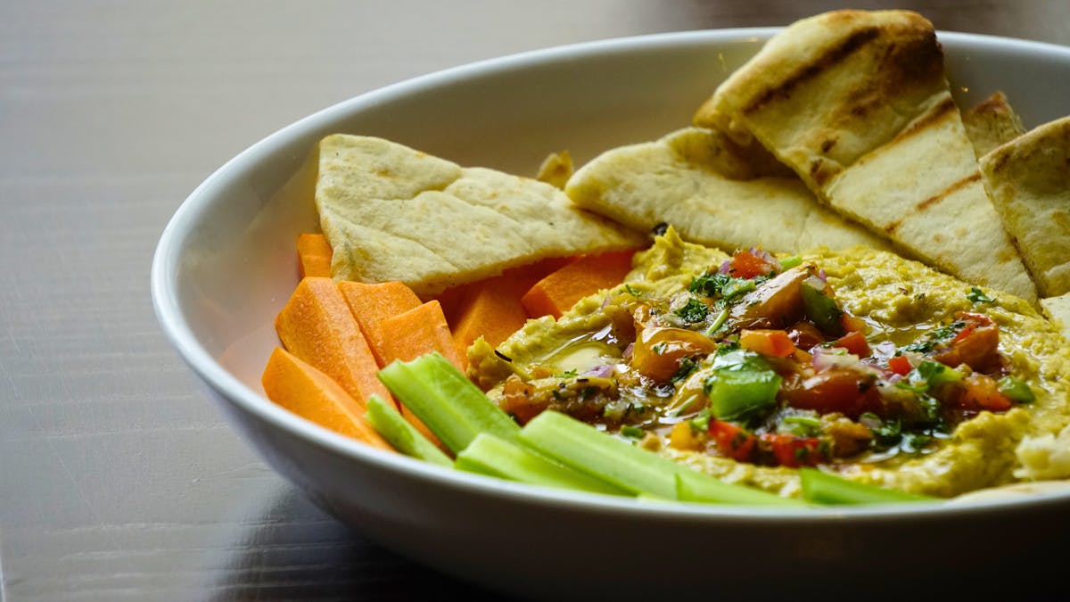 hummus topped with seasonal gremolada, served with fresh crudité and grilled naan