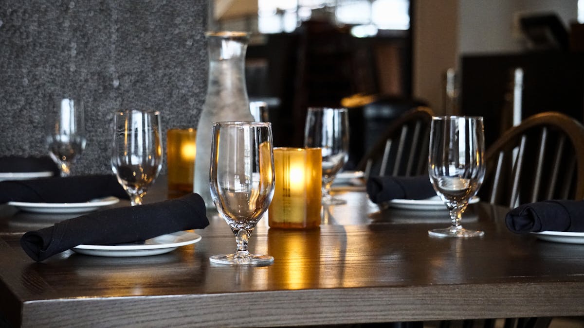 a glass of wine sitting on top of a wooden table