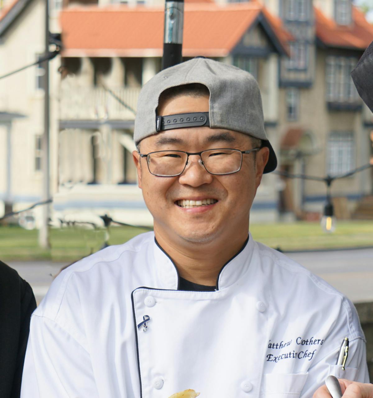 a man wearing glasses and smiling at the camera