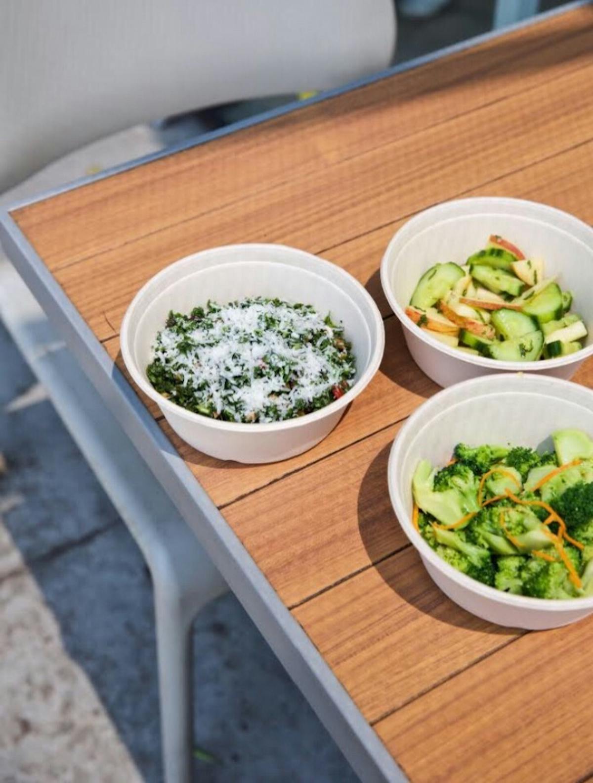 a bowl of salad on a plate on a table