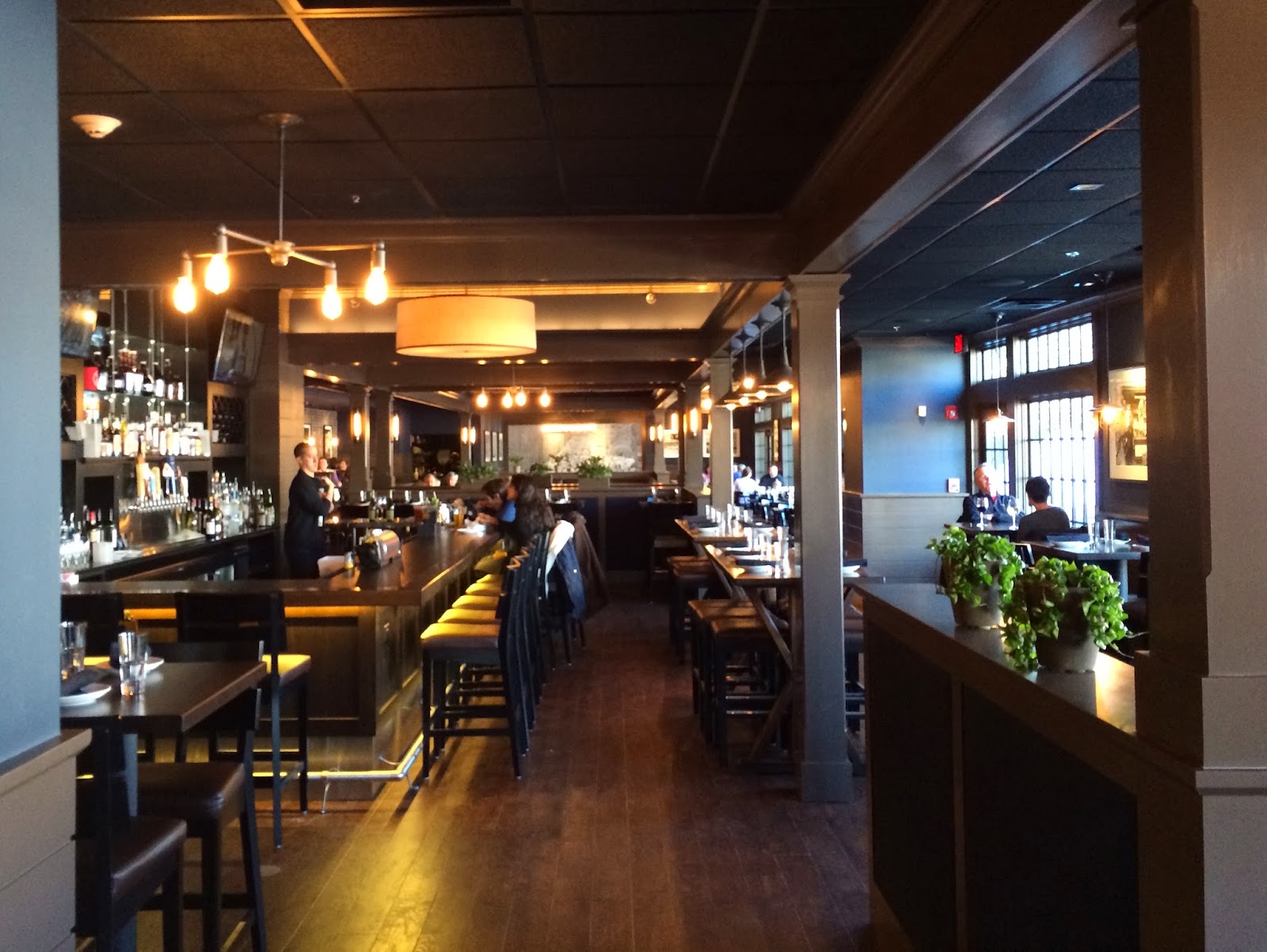 a room with a bar and people sitting at tables