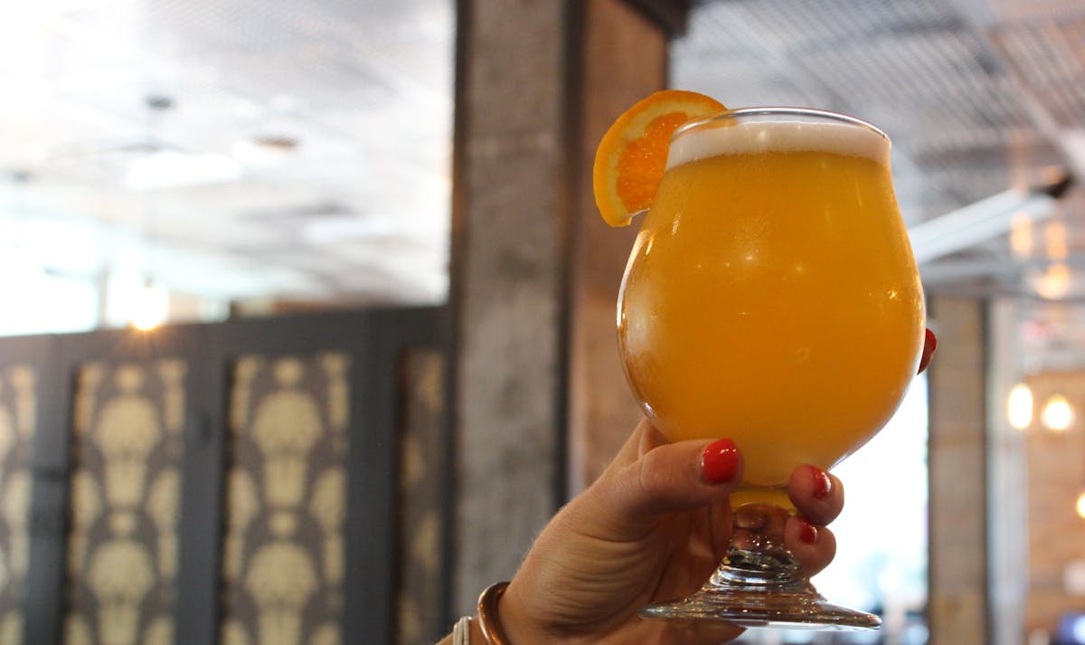 a hand holding a glass of orange juice
