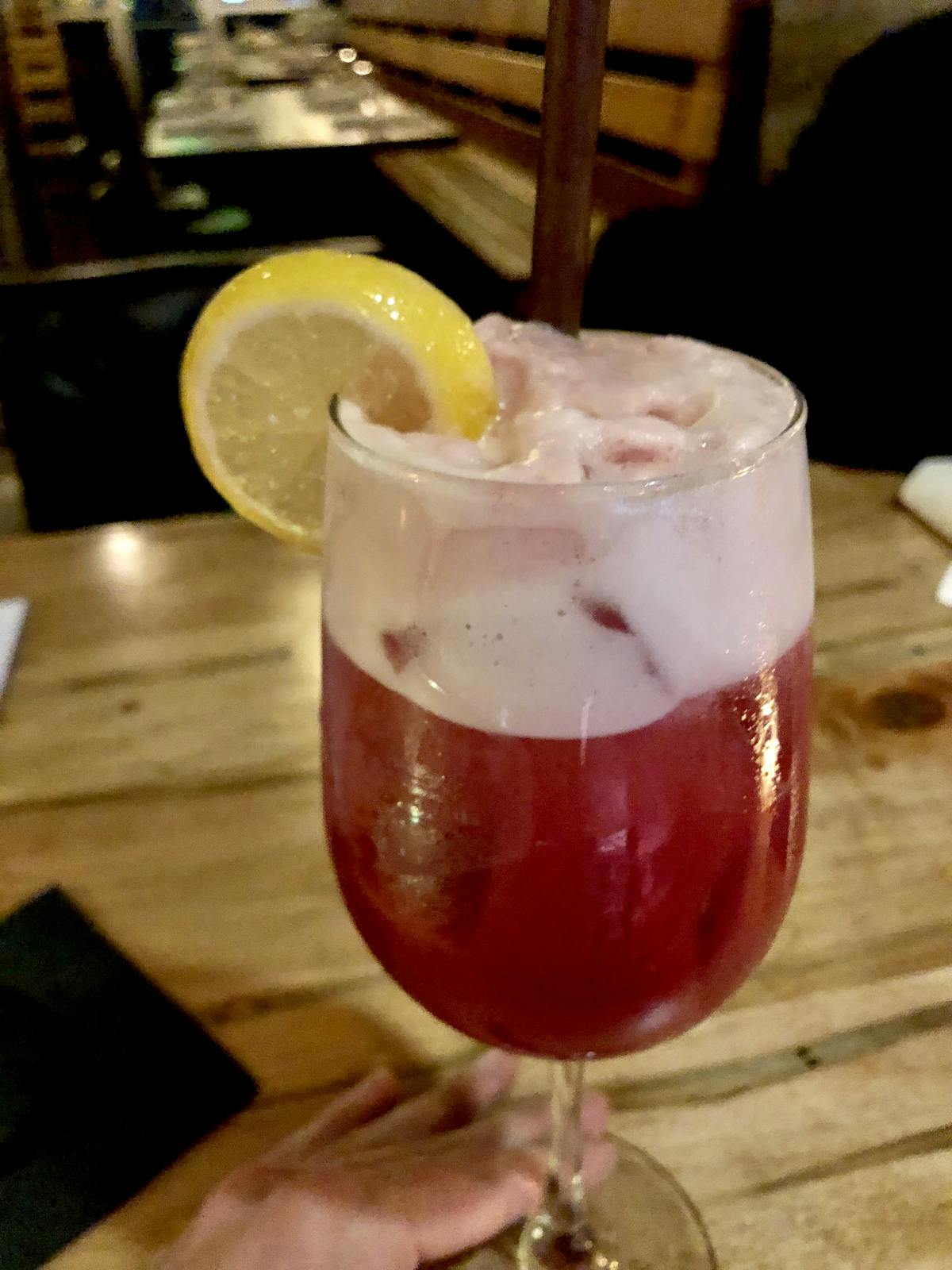 a glass of wine sitting on top of a wooden table