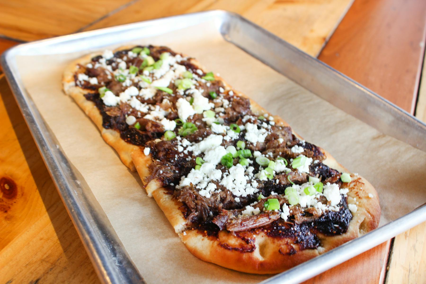 a slice of pizza sitting on top of a wooden cutting board