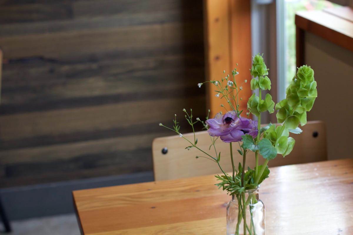 a vase of flowers sitting on top of a wooden table