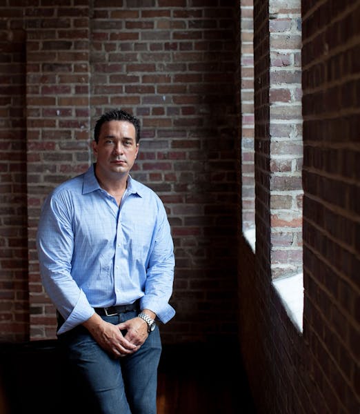 a man standing in front of a brick building