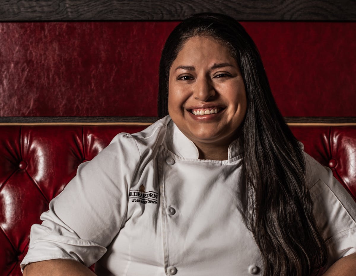 a person sitting at a table smiling for the camera