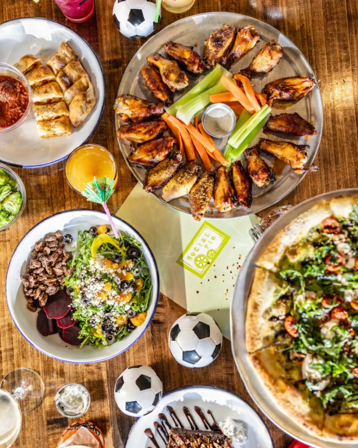 a table with plates of food and football balls