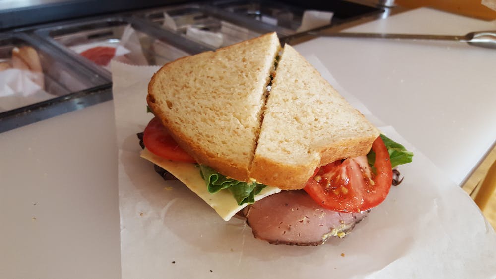 a cut in half sandwich sitting on top of a paper plate