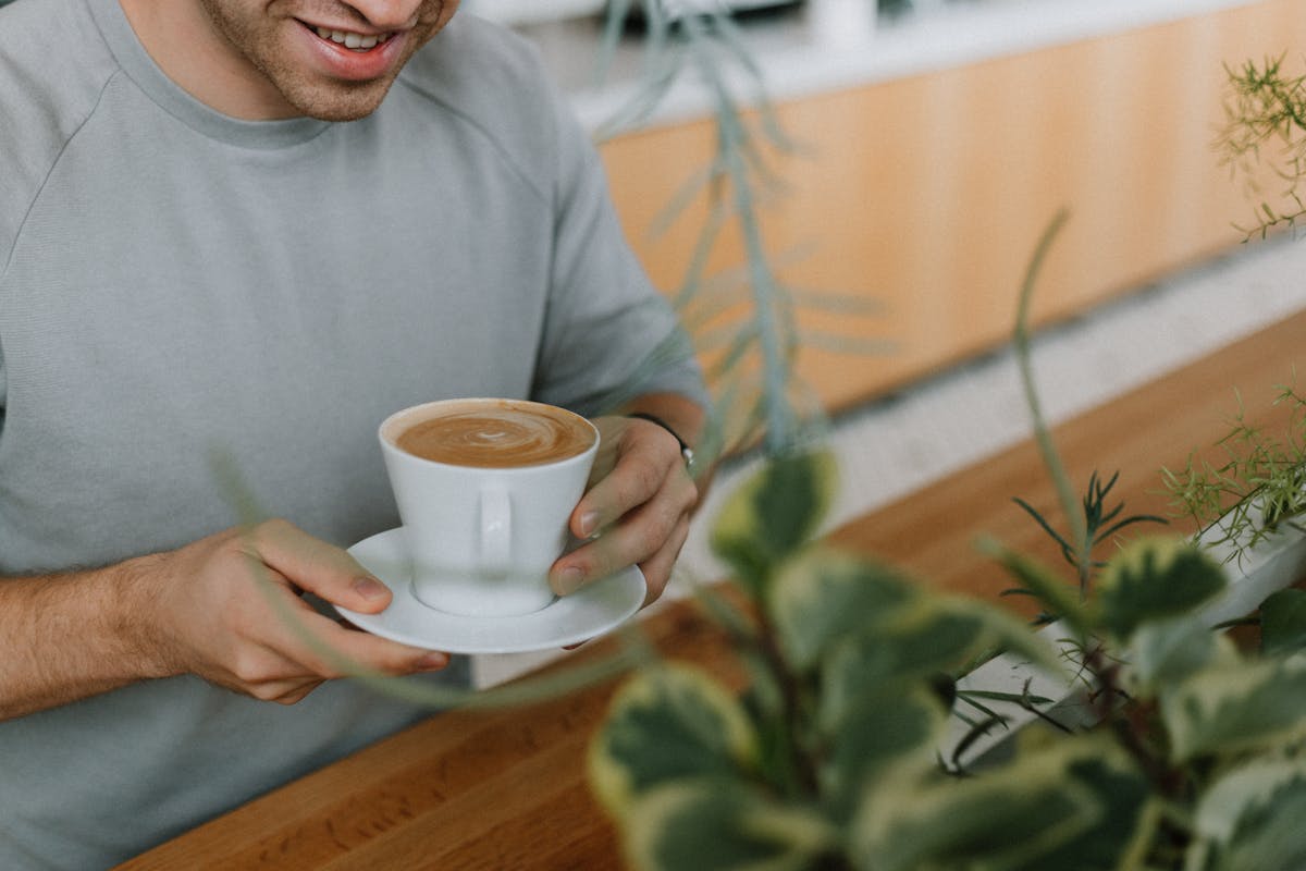 a man sitting at a table with a cup of coffee