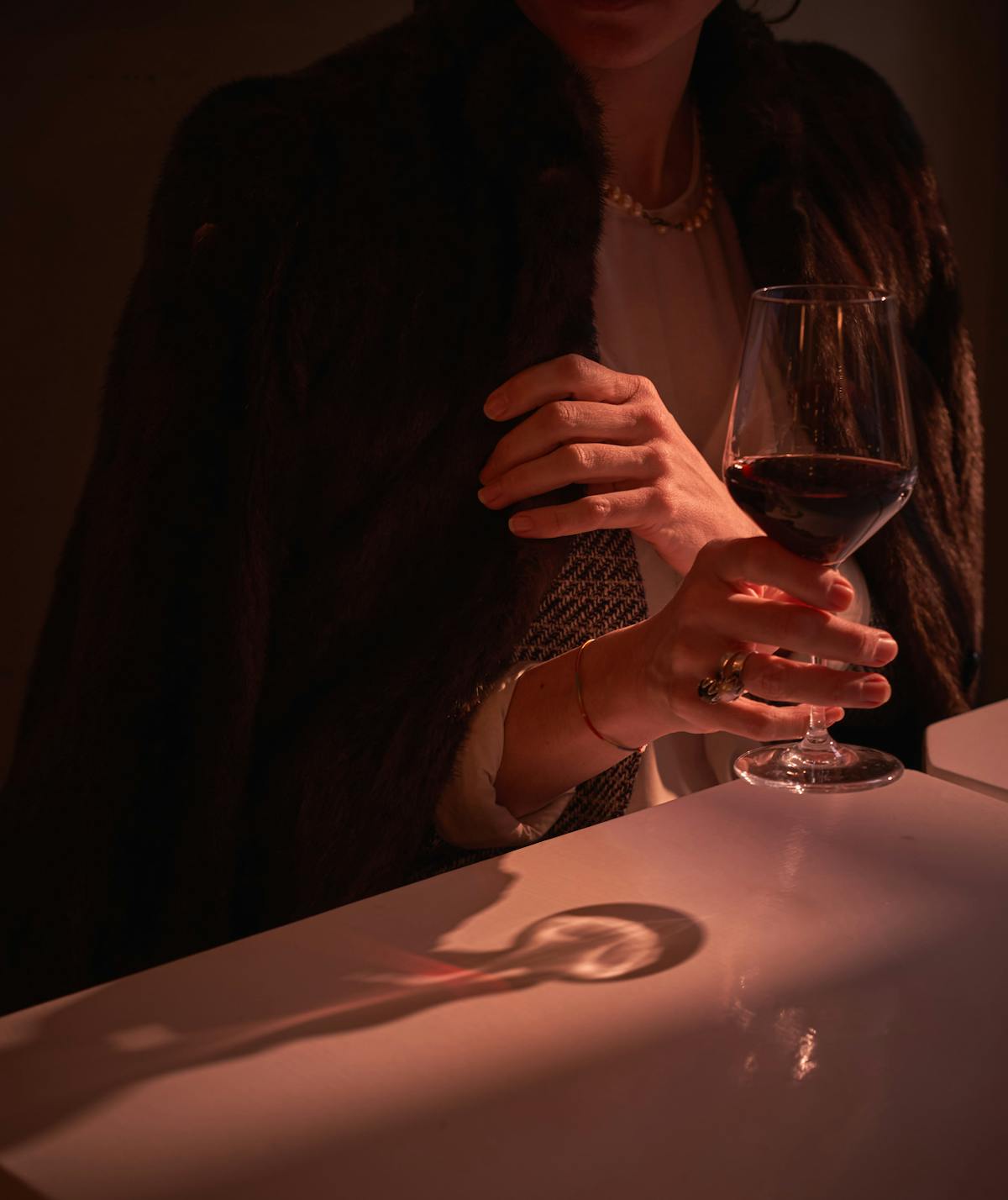 a person sitting at a table with wine glasses