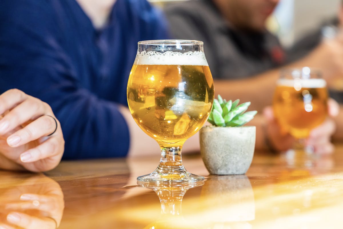 a person sitting at a table with a glass of wine