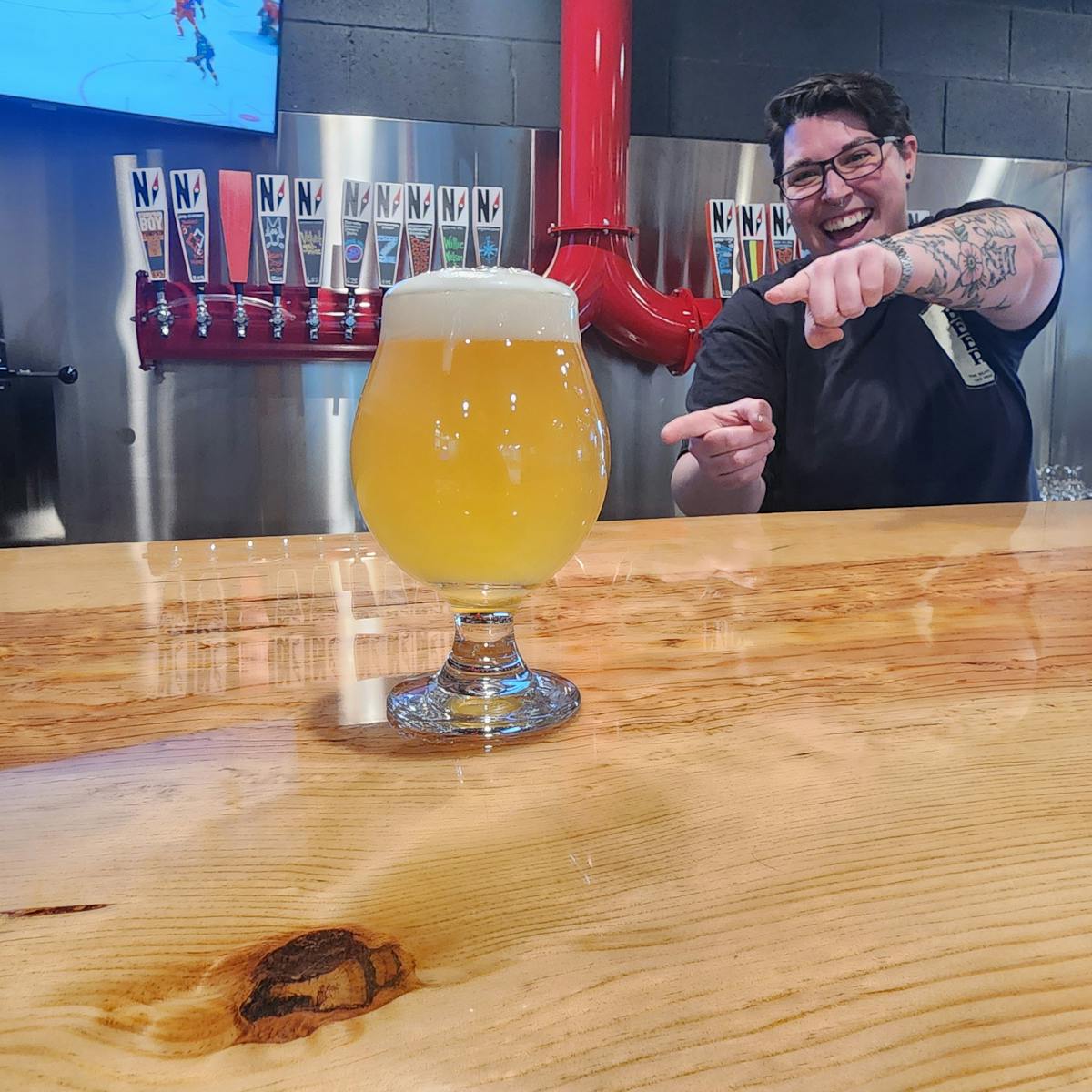 a person holding a glass of beer on a table