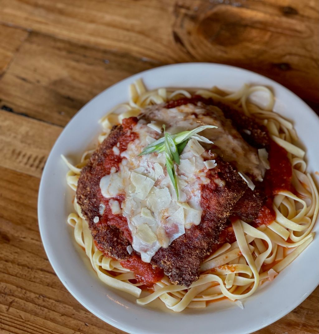 a spoon above a wooden cutting board