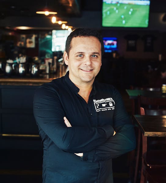 a man standing in front of a restaurant