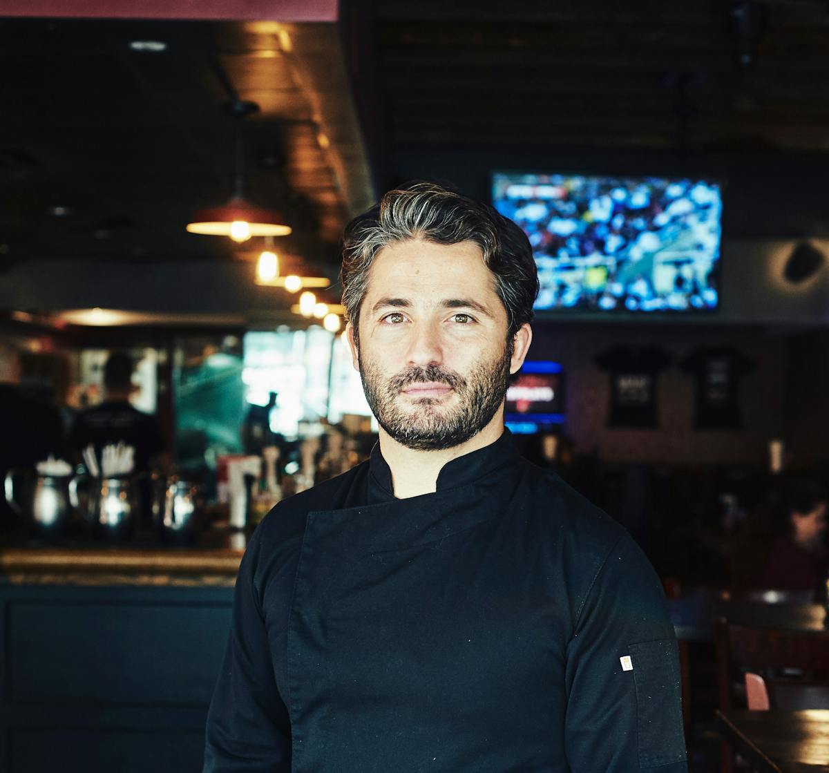 Sandro Cuomo standing in front of a bar