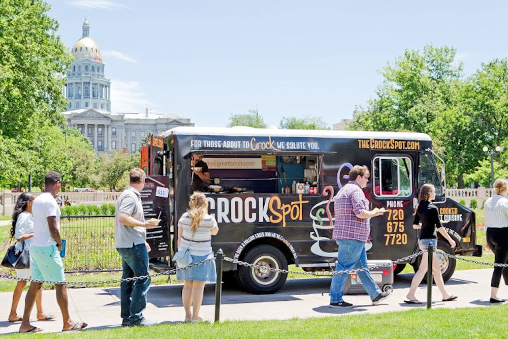 Food truck parked, customers around it