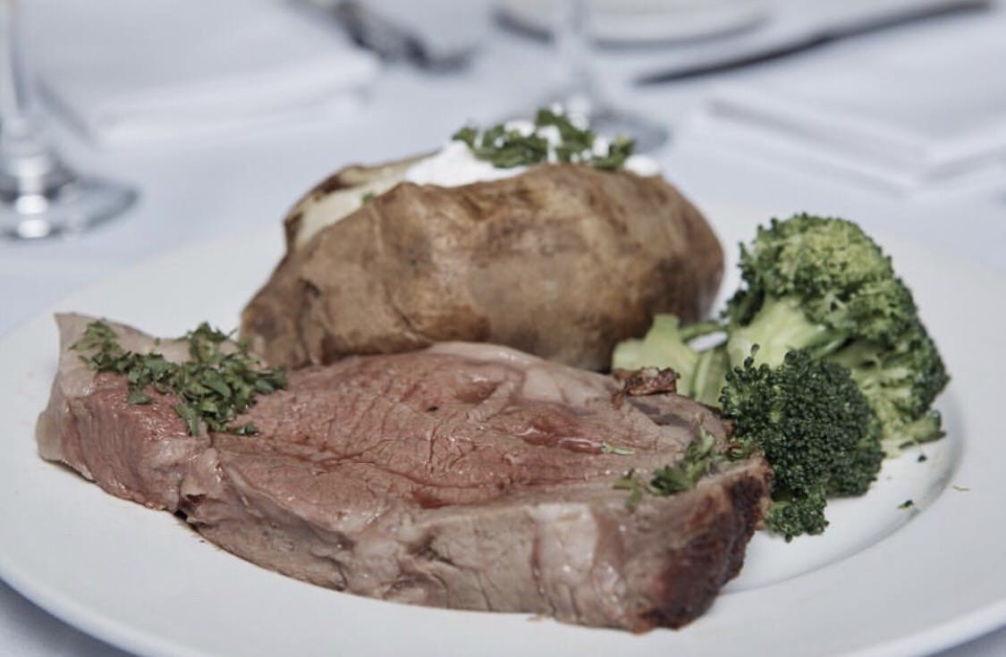 a white plate topped with meat and vegetables