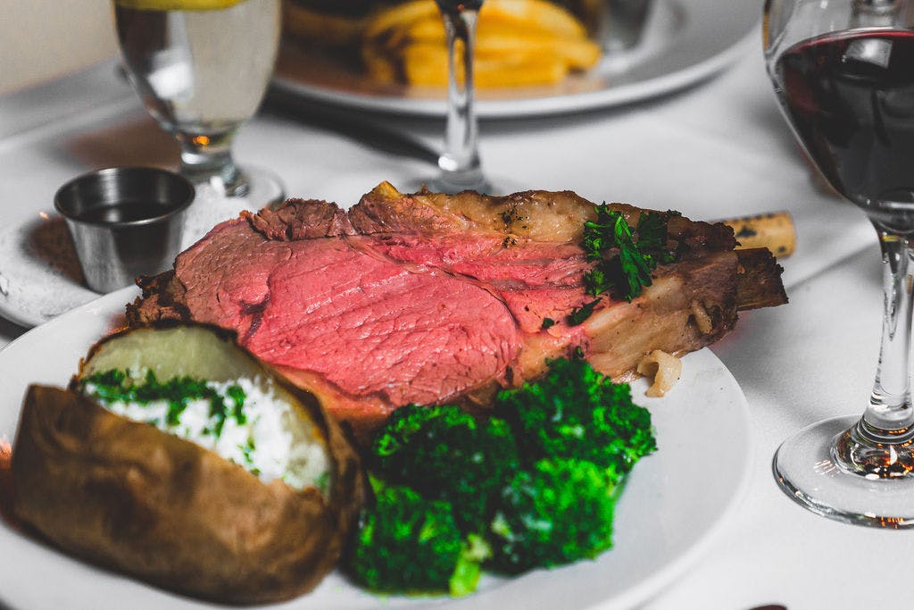 a close up of a plate of food and glasses of wine