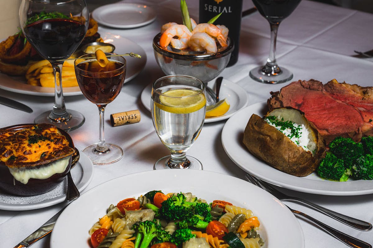 a plate of food and glasses of wine on a table