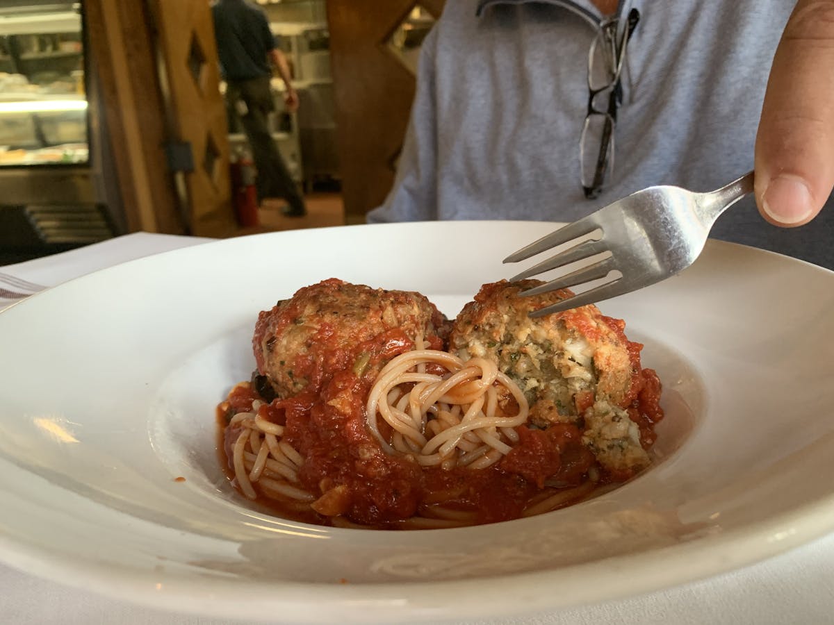 a person sitting at a table with a plate of food