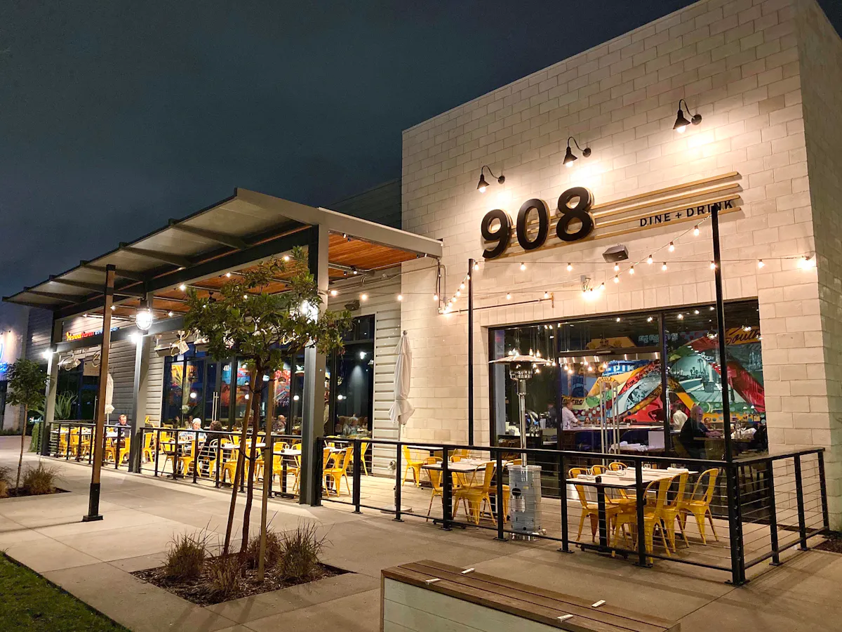 The patio of the restaurant with guest sitting at tables with a view into the bar area