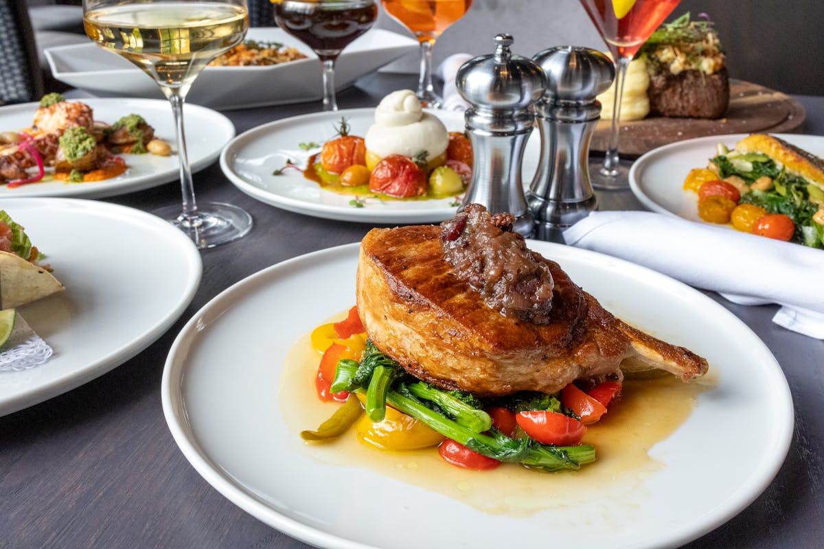 Berkshire Pork Chop plated with other dishes in background