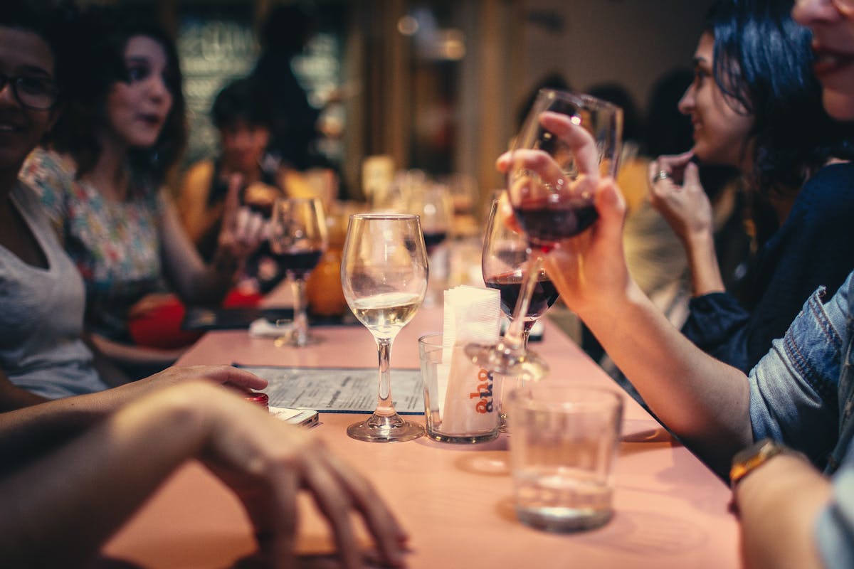 a group of people sitting at a table with wine glasses