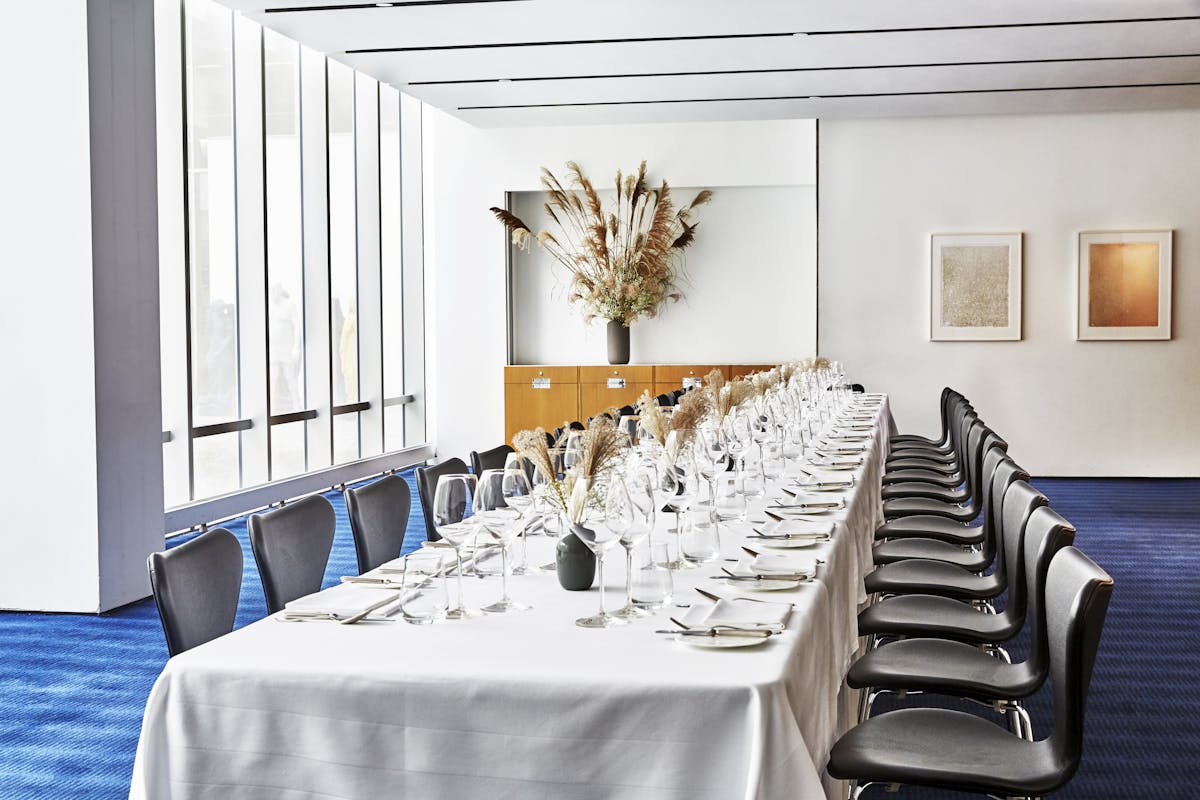 An airy, light-filled view of a large table for 26 guests in The Modern's private dining room.