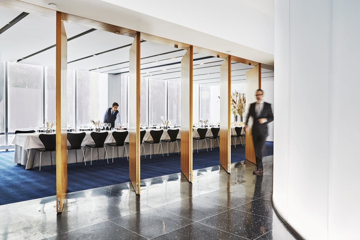 A view from the main dining room towards the private dining room as servers prepare for an event