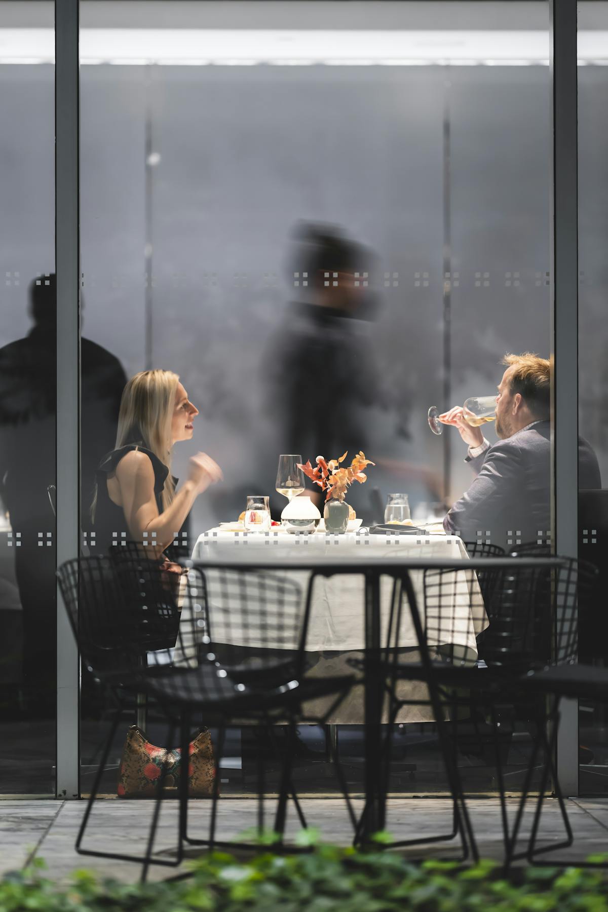 a group of people sitting at a table in front of a window