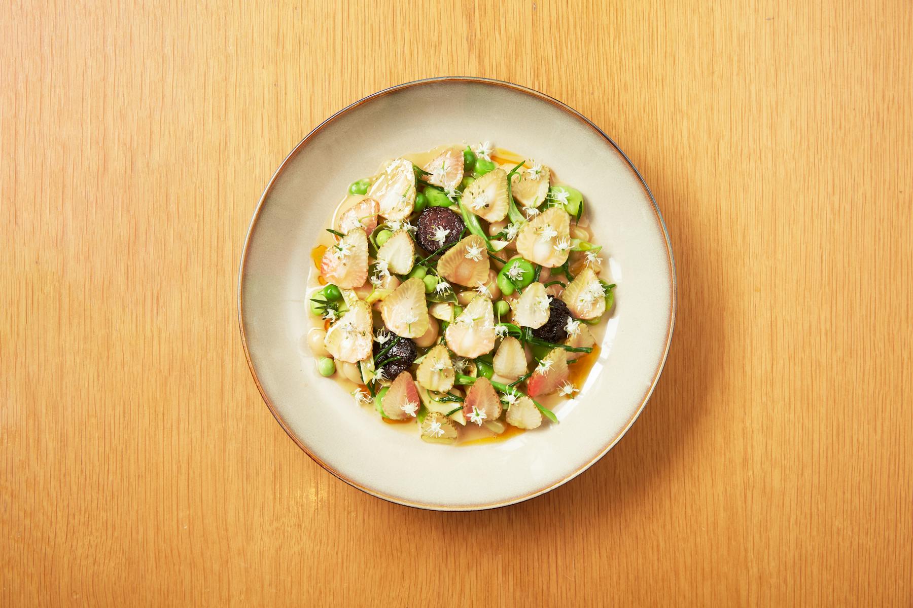 a bowl of food sitting on top of a wooden table