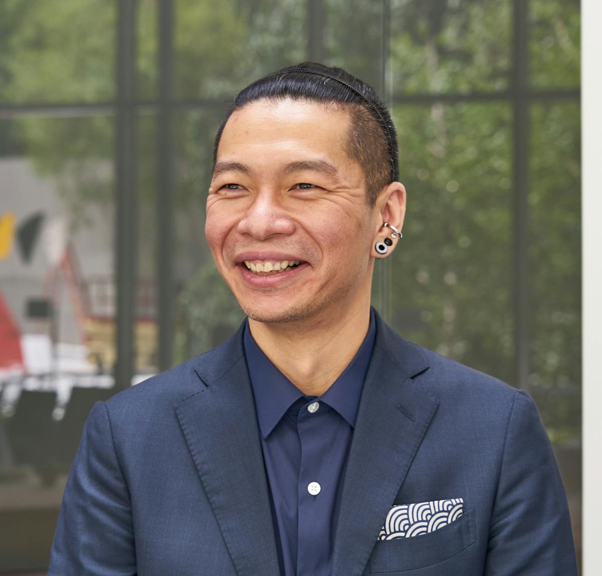 a man wearing a suit and tie smiling at the camera